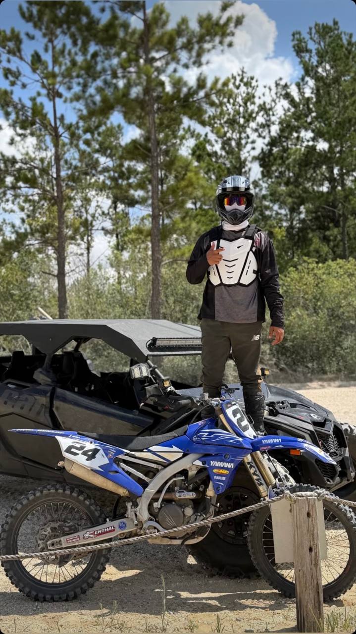 Piloto con casco junto a su moto Yamaha 24